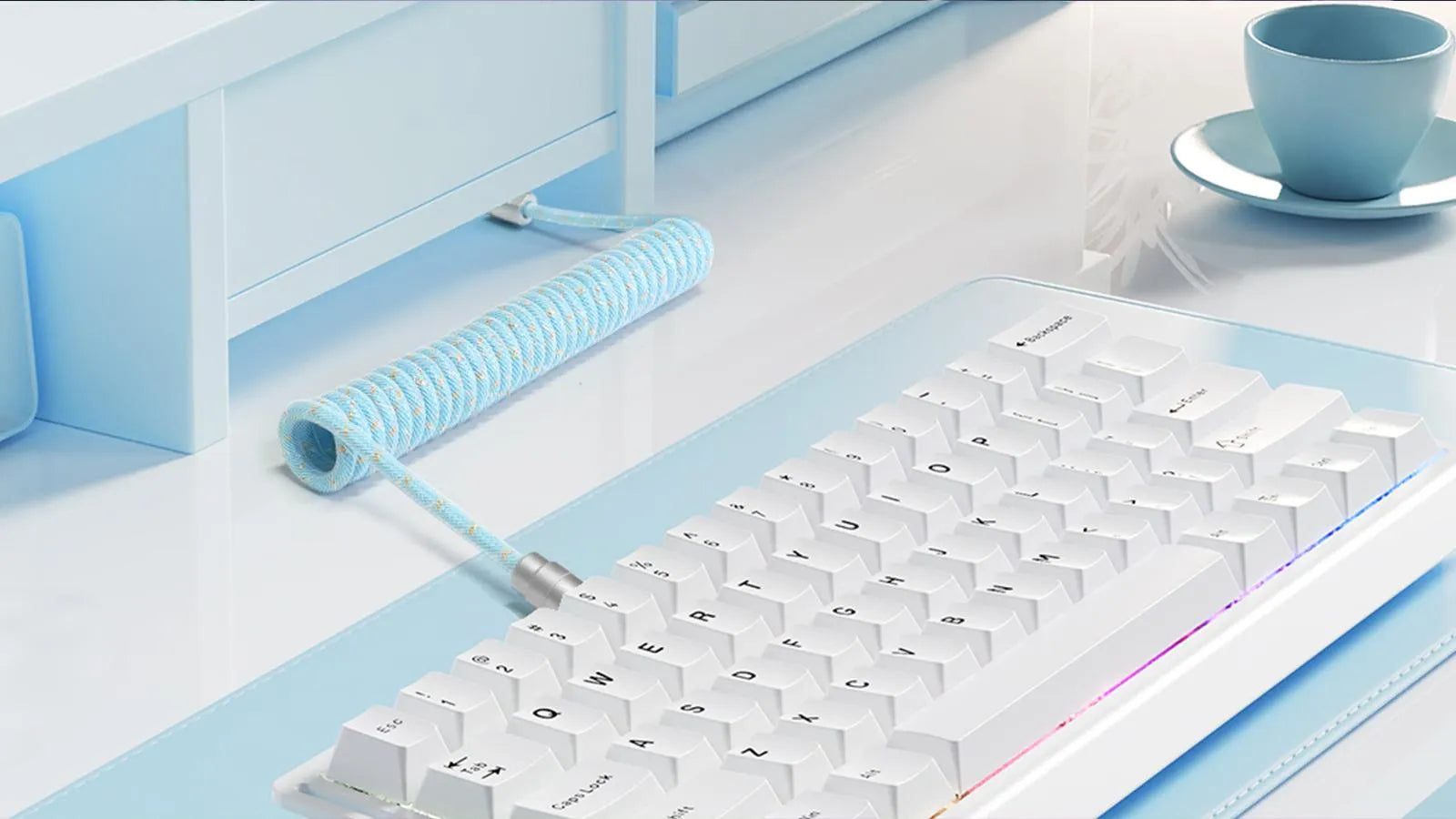 MAMBASNAKE coiled keyboard cable arranged on a desk beside a keyboard and monitor