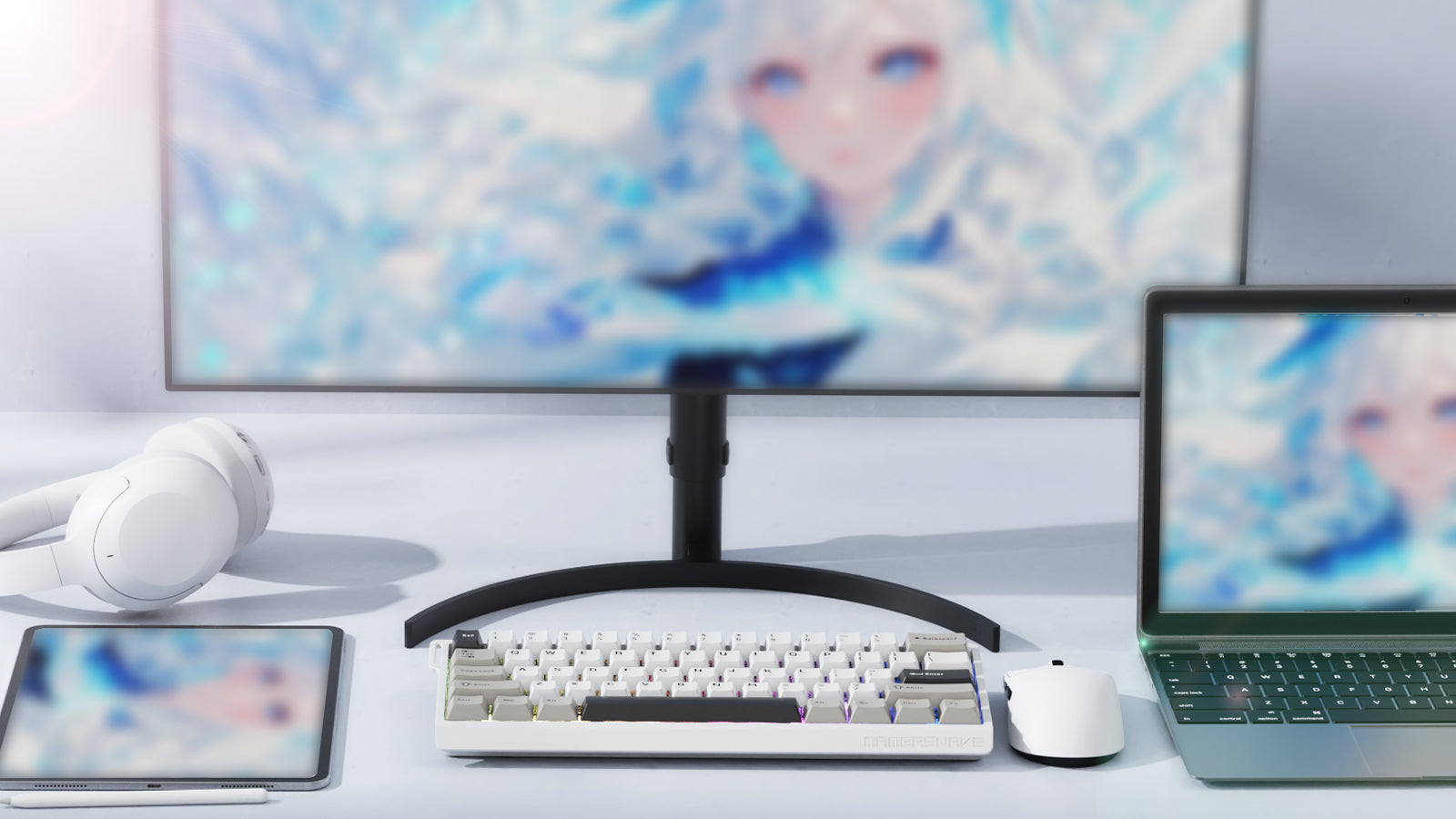 A clean, modern desk setup with a laptop, monitor, tablet, mechanical keyboard, and other peripherals