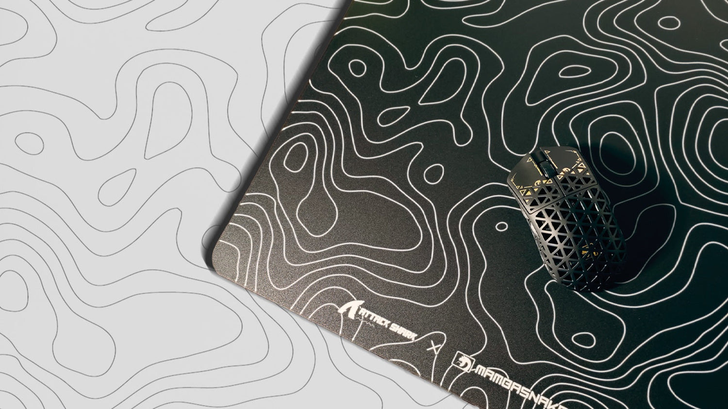 A black lightweight gaming mouse on a mousepad with a white topographic map design, on a matching white and grey surface