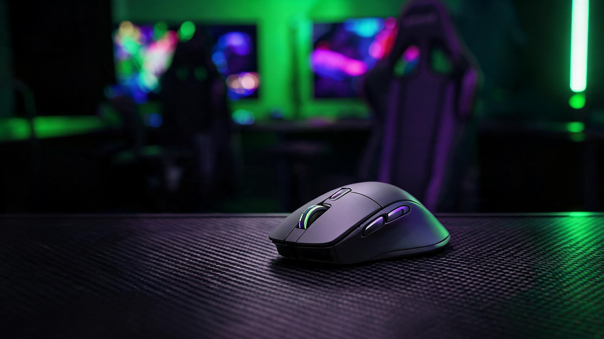 Black wireless gaming mouse on a carbon-fiber desk in a neon-lit gaming setup, with dark space on the left