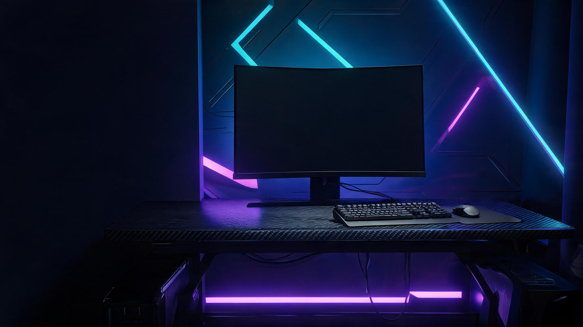 Dark gaming desk with vivid cyan and violet lighting, a monitor as the focal point, and open workspace for keyboard and mouse