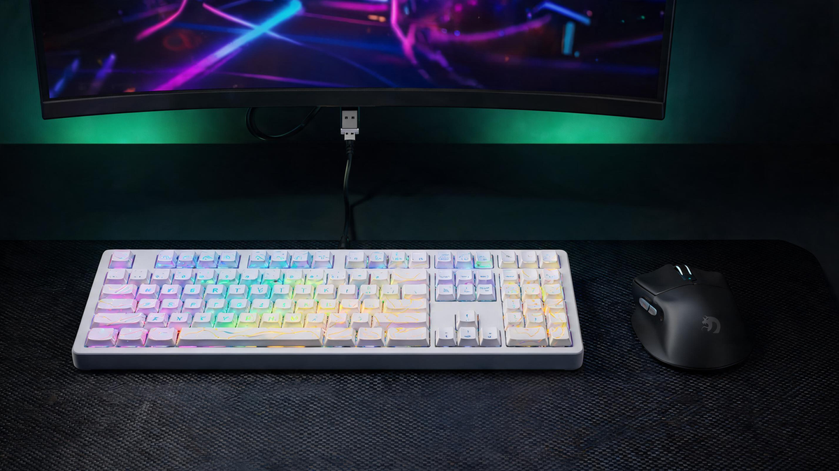 Wireless mouse and keyboard arranged on a dark gaming desk beside a computer, with the receiver positioned in the active workspace.