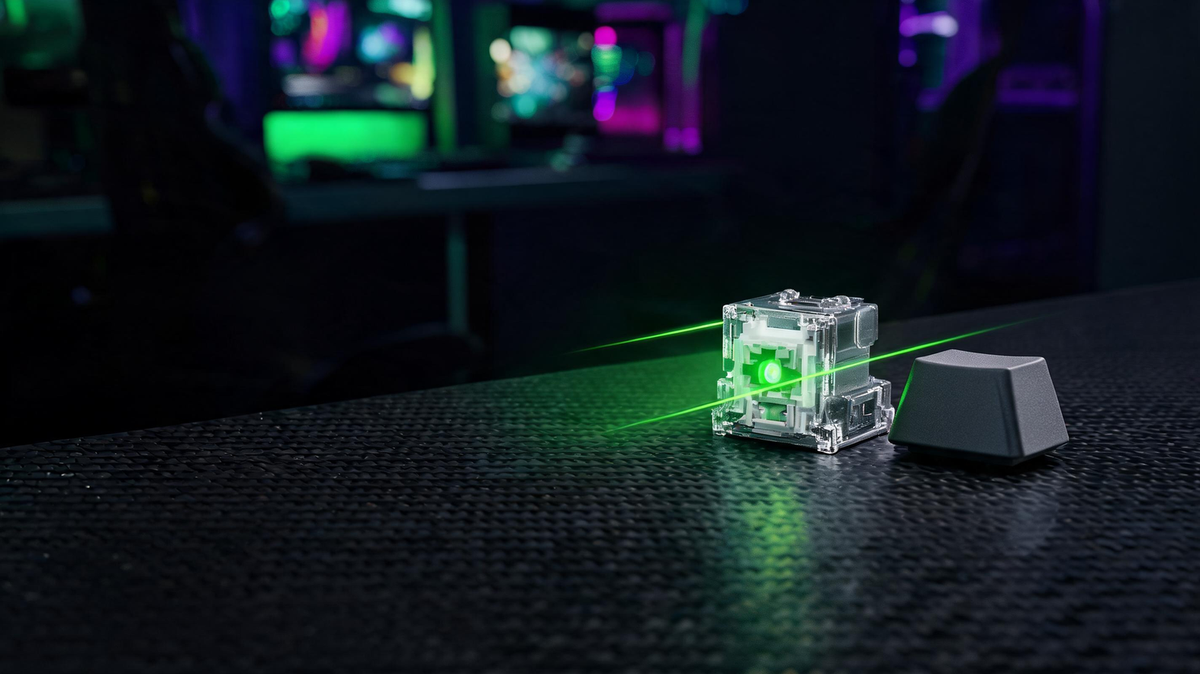 Dark gaming desk scene with a keyboard keycap, optical switch mechanism, and a visible light path diagram.