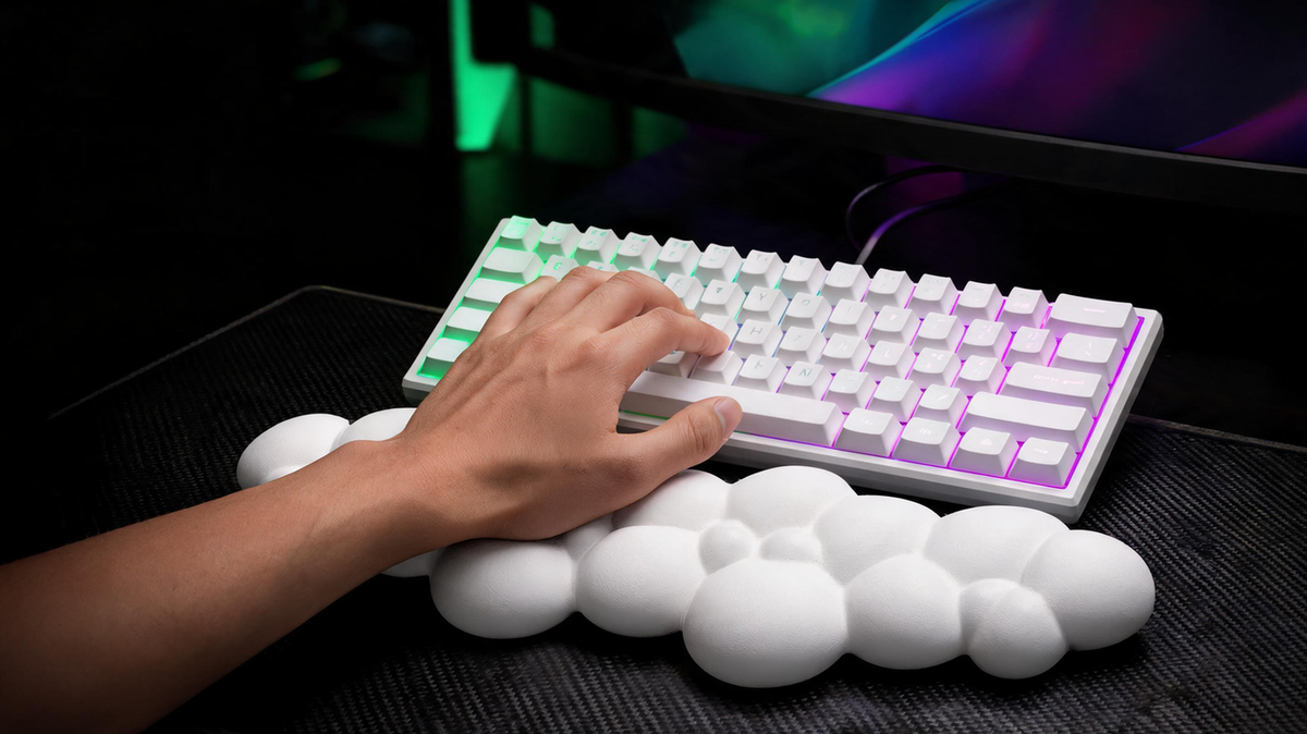 Padded keyboard wrist rest supporting the heel of a gamer’s palm in a neon-lit gaming setup