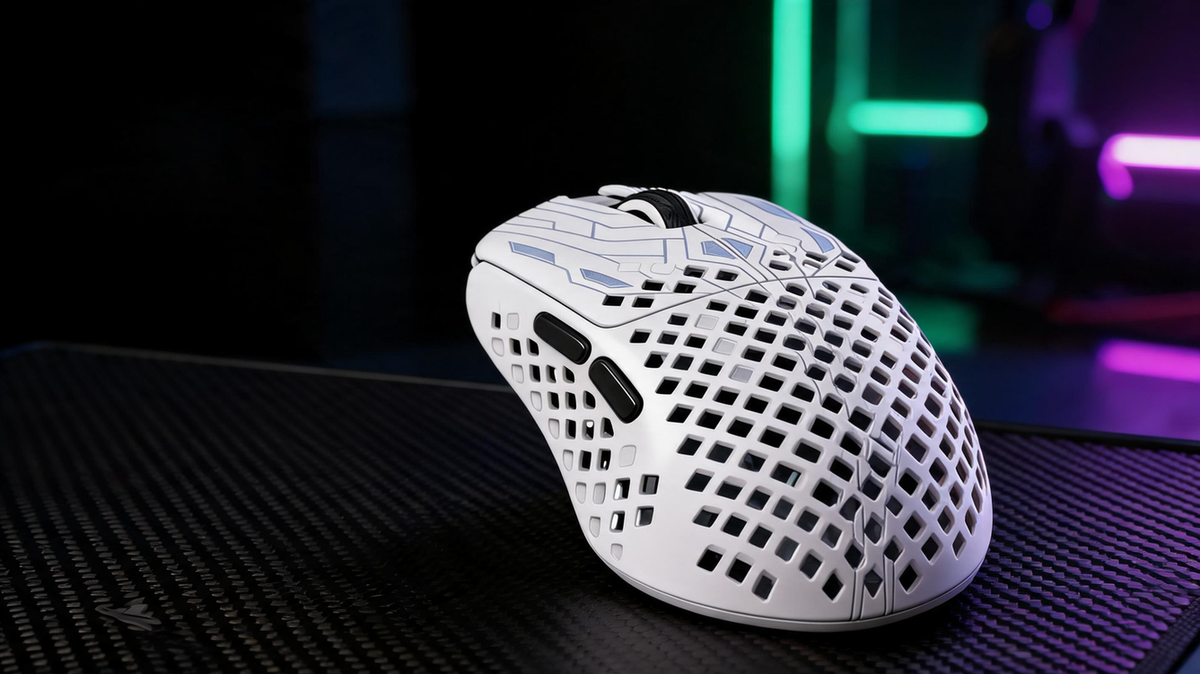 Honeycomb-shell lightweight gaming mouse on a carbon-fiber gaming desk under saturated green and purple lighting