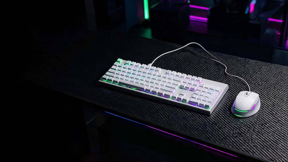 Coordinated white gaming keyboard and mouse on a carbon-fiber desk in a dark RGB-lit gaming room, with open dark space on one side for headline placement