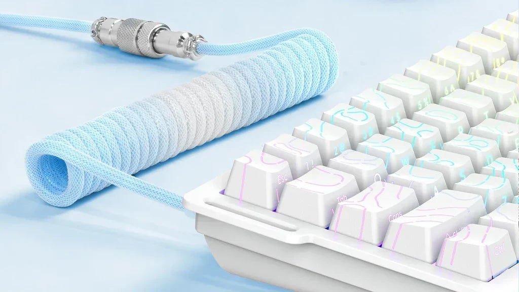 Light blue coiled cable with knurled silver aviator connector and pastel gradient keycaps on a white keyboard.