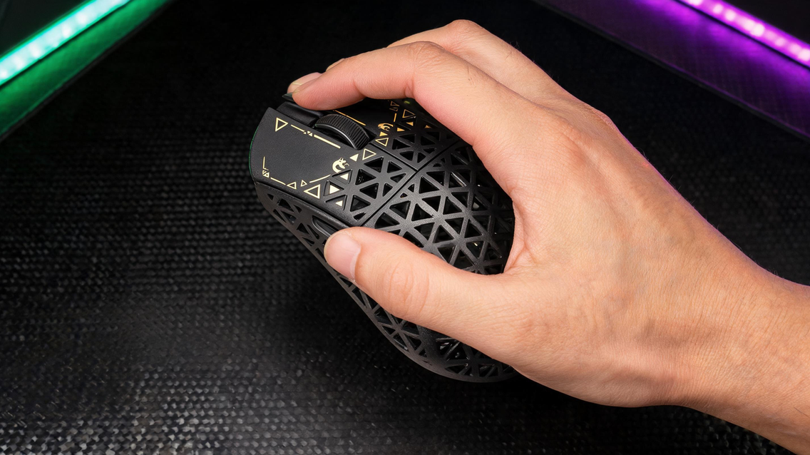 MAMBASNAKE M5 Ultra carbon-fiber wireless gaming mouse in a dark esports setup with vivid neon green and purple lighting, positioned beside open negative space for the headline