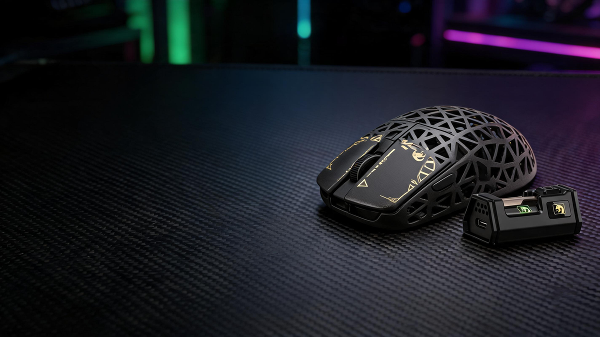 MAMBASNAKE M5 Ultra carbon-fiber wireless gaming mouse on a carbon-fiber desk in a neon-lit gaming setup