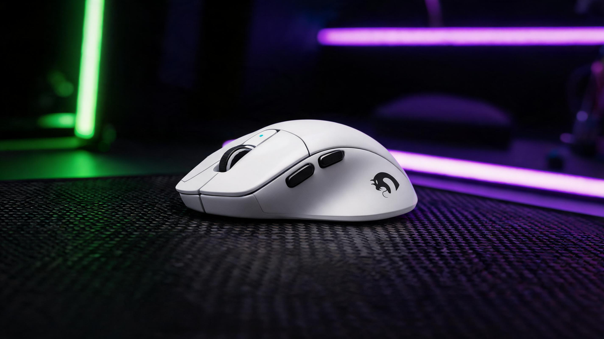 White MAMBASNAKE M3 wireless gaming mouse on a carbon-fiber desk in a dark gaming setup with vivid neon green and purple lighting, with open dark space for the article title