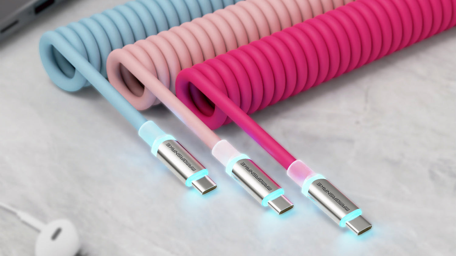 Three coiled USB-C cables in light blue, pink, and magenta, with illuminated connectors on a marble-like surface