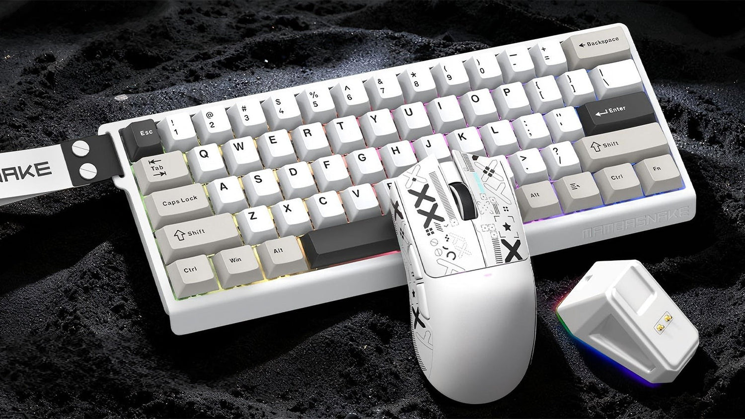 A white Mambasnake keyboard and matching patterned mouse on a lunar-like surface with a glowing USB receiver