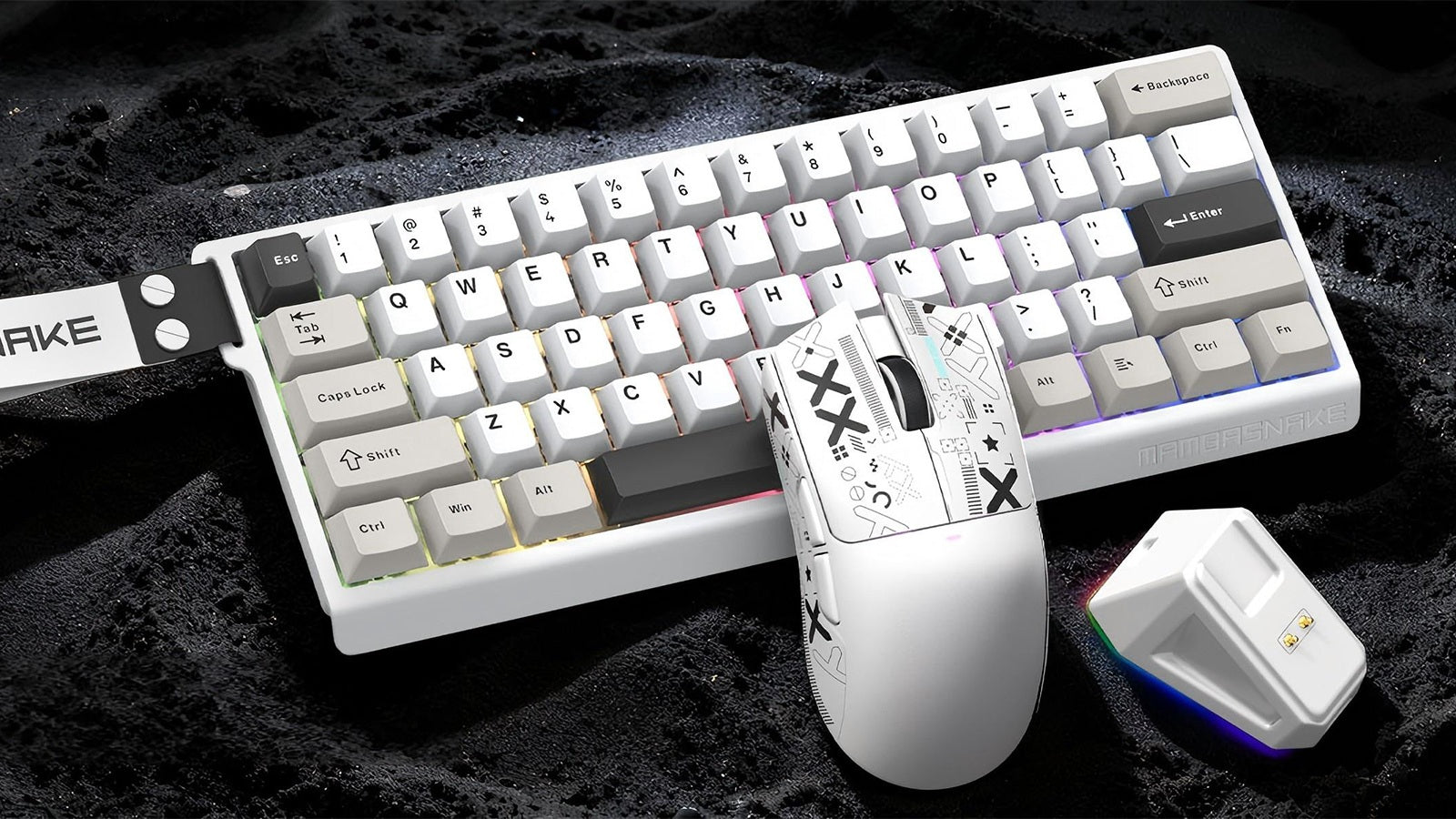 A white Mambasnake keyboard and matching patterned mouse on a lunar-like surface with a glowing USB receiver