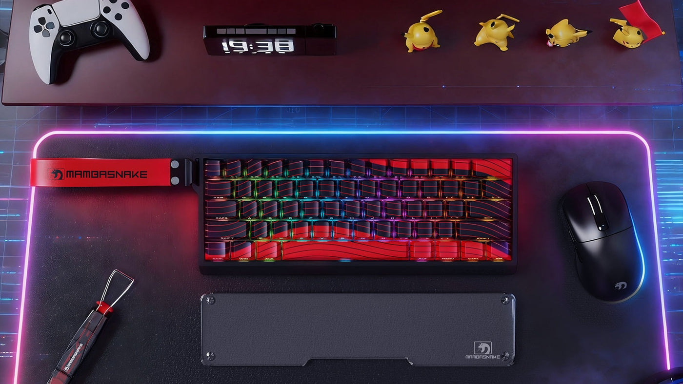 Top-down gaming desk with a red MAMBASNAKE RGB keyboard, mouse and illuminated desk mat